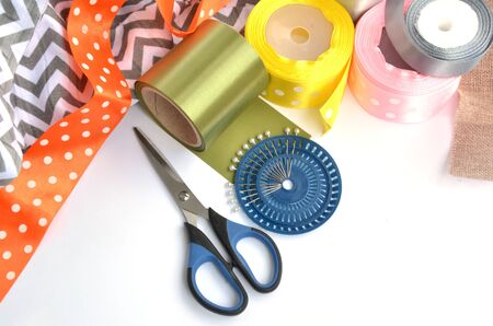 Flat lay made by color ribbons, scissors and pins on white backgroundの写真素材