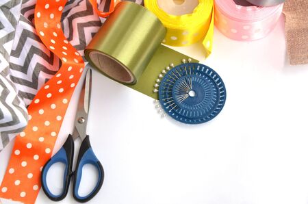 Flat lay made by color ribbons, scissors and pins on white backgroundの写真素材