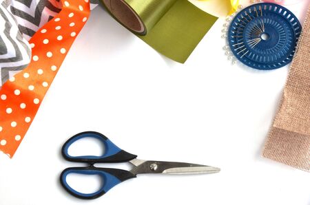 Flat lay made by color ribbons, scissors and pins on white backgroundの写真素材