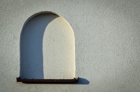 background or texture blank arched window on the light wallの写真素材