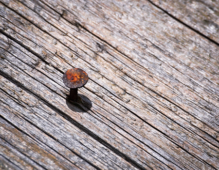 abstract background rusty nail in an old wooden boardの写真素材