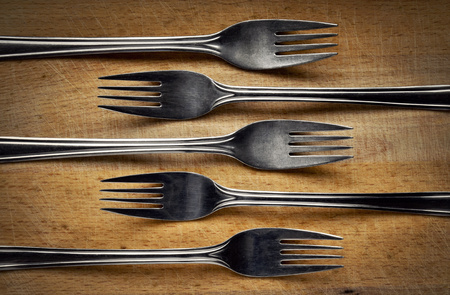 background stainless steel fork on cutting boardの写真素材