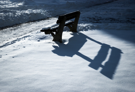 seasonal background shadow on the bench early evening snowの写真素材