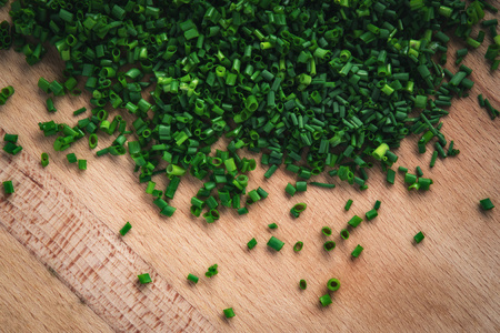 background Chives on a wooden kitchen boardの写真素材