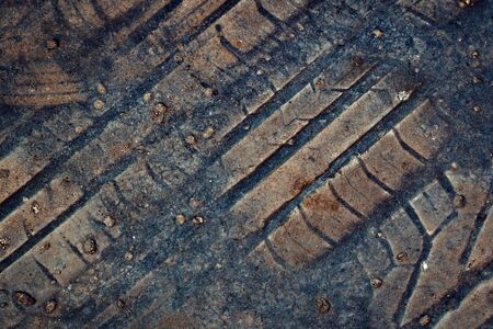 abstract background or texture imprint of rubber tread pattern on old asphaltの写真素材
