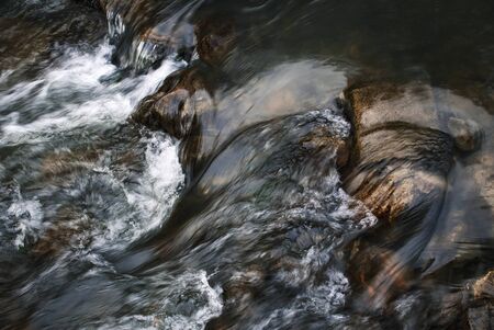 nature seasonal background Detail of fast flowing dark riverの写真素材