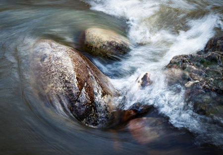 abstract nature background the water of the river flows around the stonesの写真素材