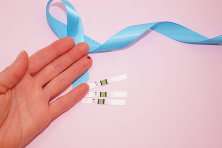 World Diabetes Day is November 14. Blue ribbon, test strips, blood on the finger.