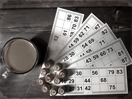 Board game lotto. Wooden lotto barrels and game cards for a game in lotto with cup of coffee. The...