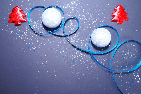 New Years layout: 2 balls, 2 red Christmas trees, shiny confetti. Dark background. Top view.