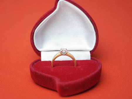 Beautiful shiny gold ring with a large diamond of high quality. In a red velvet box in the shape of...