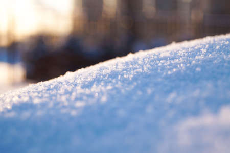 Fresh thick layer of snow close-up. Winter landscape with a blurry background. Sun rays.の写真素材