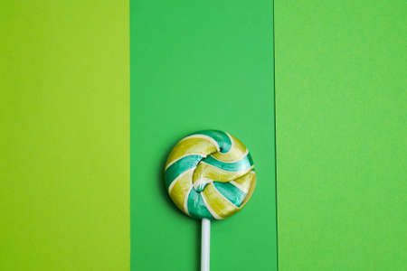 Multicolored round lollipop on a green background of three different shades. Space for copying. valentines day.の写真素材