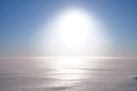 Gulf of Finland in winter. Bright blinding sun on a blue sky background.
