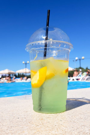 Refreshing mojito on the side of the pool. Summer heat. Blurred background. Selective focus.