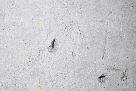 Cracks on the gray wall. Cement background. The concept of unfinished repairs.