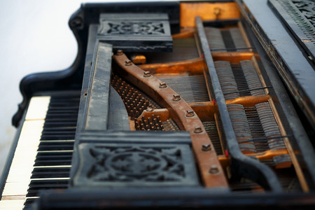 Old piano detail with keyboard, wooden carved ornament and mechanicsの写真素材