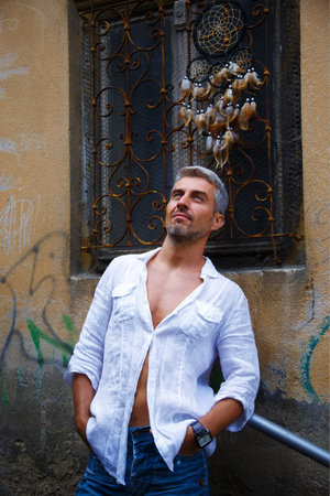 Man in a white shirt and ornamental window on background. の写真素材