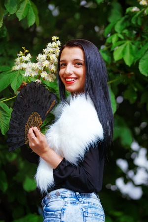 Smiling young woman smelling a beautifull Spring Magic, and beautiful ornamental fan and white fur. Flower backgroundの写真素材