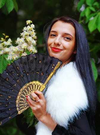 Smiling young woman smelling a beautifull Spring Magic, and beautiful ornamental fan. Flower backgroundの写真素材