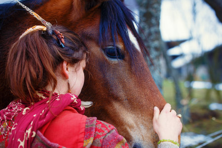 Portrait woman and horse in outdoor. Woman hugging a horse and has feather in her hair.の写真素材