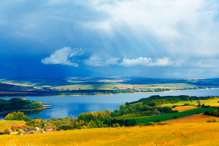 Beautiful landscape, green and yellow meadow and lake with mountain in background. Slovakia, Central...