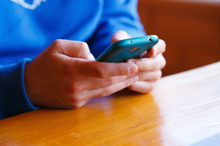 man with  restaurant and playing on a smartphone.