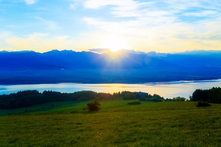 Beautiful landscape, green meadow and lake with mountain in background. Slovakia, Central Europeの写真素材
