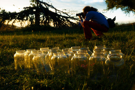 Set of empty bottling jars at sunset with miraculous evening light. with photographer on the backgroundの写真素材