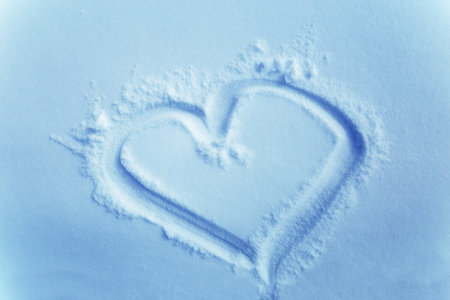 heart in snow, drawing in the snow. Light blue background
