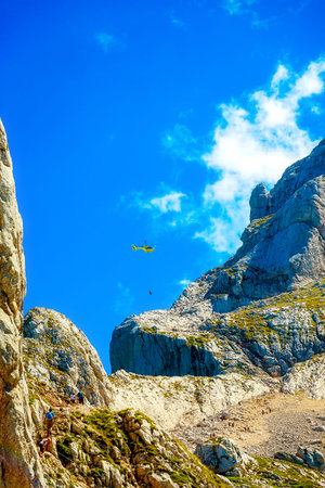 rescue mission with helicopter in alpine mountain landscapeの写真素材