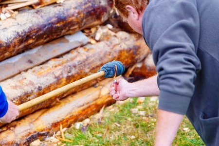 setting big bonfire made of logs on fire with torch.の写真素材