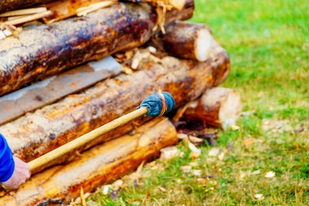 setting big bonfire made of logs on fire with torch.の写真素材
