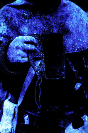 original historic leather cup in detail held by man in middle age dress. Old effect