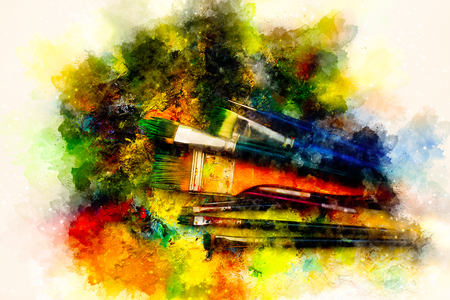 Paint brushes to the painting palette and softly blurred watercolor background.の写真素材