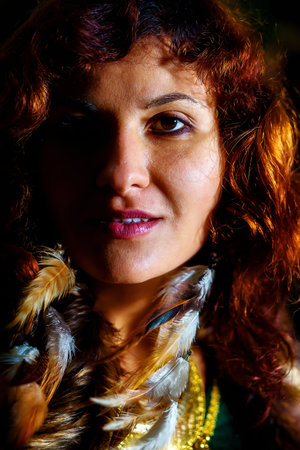 wild woman portrait with long feather earinings.