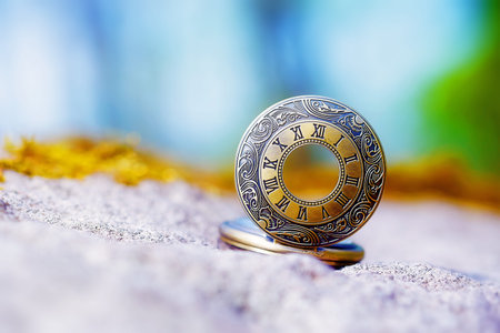 retro style gold pocket watch on rock.