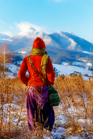 girl in colorful ethno dress standing amids winter landscape.の写真素材