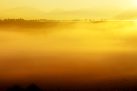 A beautiful morning landscape with sunshine and fog.の写真素材