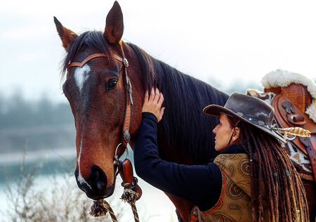 Portrait of woman and horse outdoors. Woman stroking a horse.の写真素材