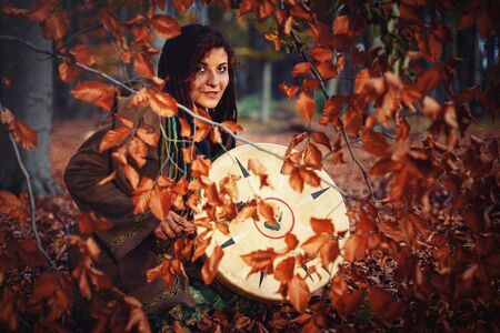 beautiful shamanic girl playing on shaman frame drum in the nature.の写真素材
