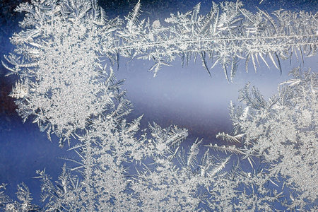 Frosty natural pattern on winter window, ornamental frost on the glass.