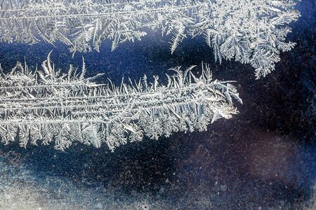 Frosty natural pattern on winter window, ornamental frost on the glass.の写真素材
