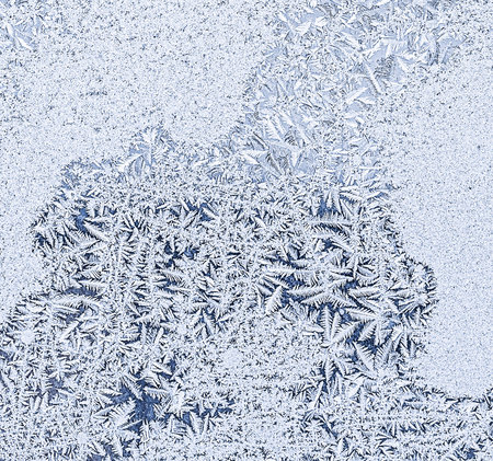 Frosty natural pattern on winter window, ornamental frost on the glass.