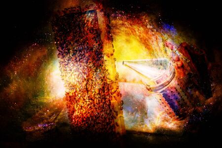 Beekeeper manipulating with honeycomb full of golden honey on abstract structured space background.の写真素材