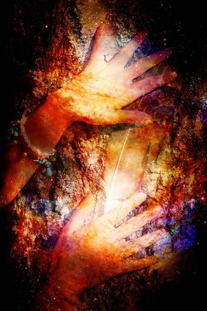 Beautiful womans hands with eagle feathers on birch crust on abstract structured spaceの写真素材