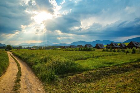 Cottages in the field Under the beautiful sky and the ray of the sunの写真素材