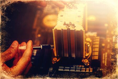 Repairman repairs the computer, Removing the computer motherboard, old photo effect.の写真素材