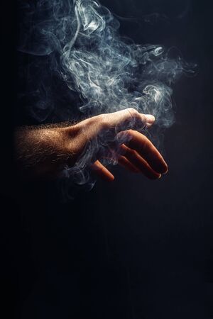 Hand in smoke on blackの写真素材