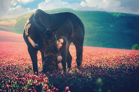 Portrait woman and horse outdoors. Woman hugging a horse.の写真素材